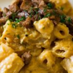 Macaroni met de vegan kaassaus en seitan spek in blokjes er over